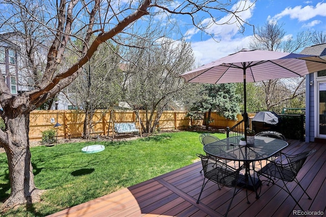 wooden deck with a lawn, a fenced backyard, and outdoor dining space