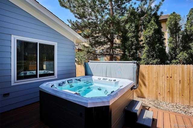 wooden terrace with a hot tub and fence