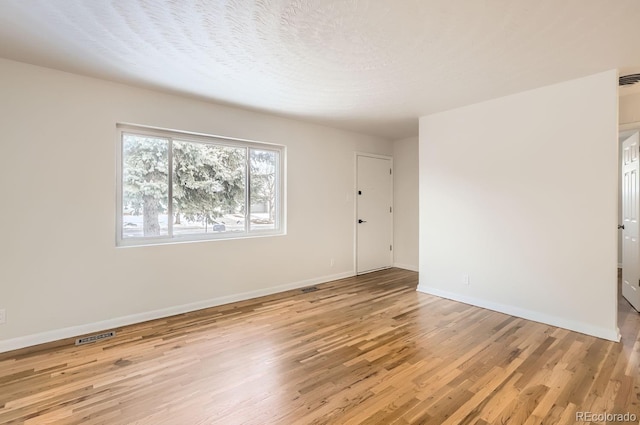 spare room with light hardwood / wood-style flooring