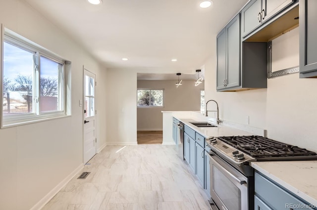 kitchen with sink, gray cabinets, stainless steel appliances, and light stone countertops