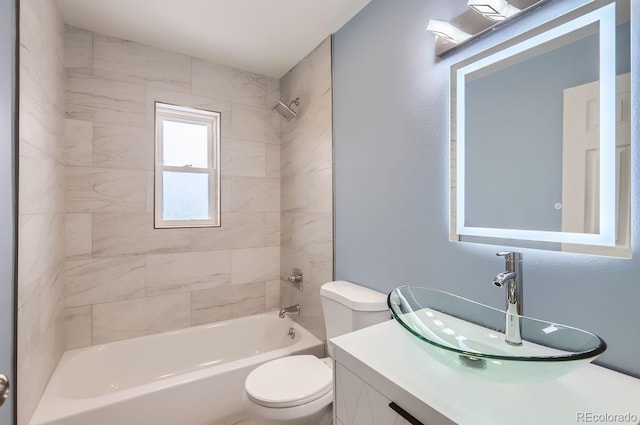 full bathroom with tiled shower / bath, vanity, and toilet