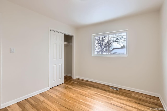 unfurnished bedroom with light hardwood / wood-style floors and a closet