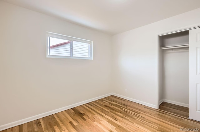 unfurnished bedroom with light hardwood / wood-style flooring and a closet