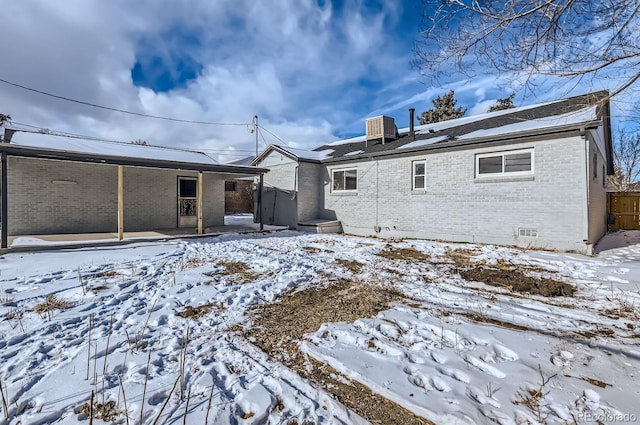 snow covered back of property featuring central air condition unit