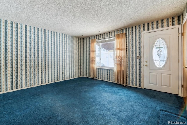 interior space featuring dark carpet and a textured ceiling