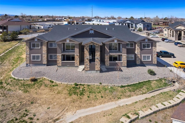 rear view of property with stone siding and a residential view