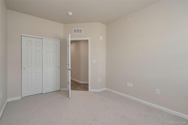 unfurnished bedroom featuring carpet floors, baseboards, visible vents, and a closet