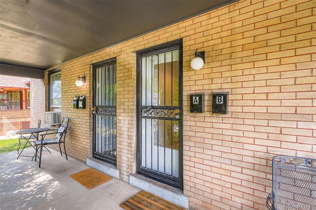 1654 S Pearl St, Denver, CO 80210 - entrance to property with covered porch, brick siding, and cooling unit
