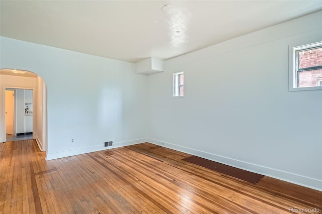 1654 S Pearl St, Denver, CO 80210 - unfurnished room with arched walkways, wood-type flooring, and plenty of natural light