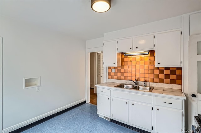 1654 S Pearl St, Denver, CO 80210 - kitchen with backsplash, light countertops, and white cabinetry