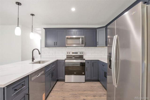 9008 Dover St, Broomfield, CO 80021 - kitchen with stainless steel appliances, a peninsula, gray cabinets, light wood-type flooring, and backsplash