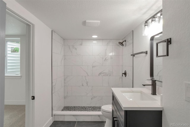 9008 Dover St, Broomfield, CO 80021 - full bath featuring vanity, a tile shower, and a textured ceiling
