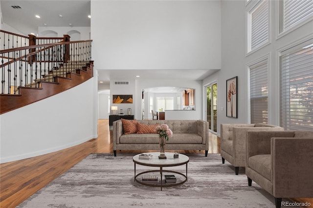 14325 N Santa Fe St, Broomfield, CO 80023 - living area featuring arched walkways, wood finished floors, a high ceiling, and stairway