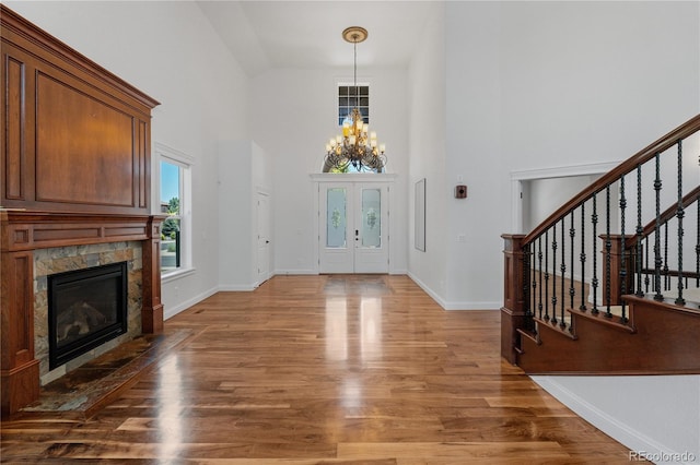 14325 N Santa Fe St, Broomfield, CO 80023 - entrance foyer with a high ceiling, a chandelier, stairway, wood finished floors, and a fireplace with flush hearth