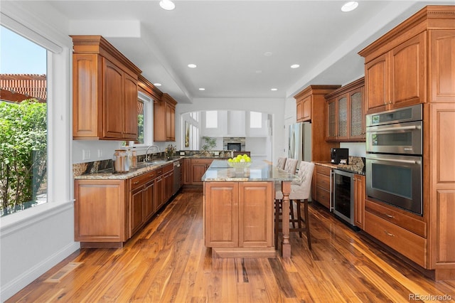 14325 N Santa Fe St, Broomfield, CO 80023 - kitchen featuring wine cooler, appliances with stainless steel finishes, a kitchen island, wood-type flooring, and recessed lighting