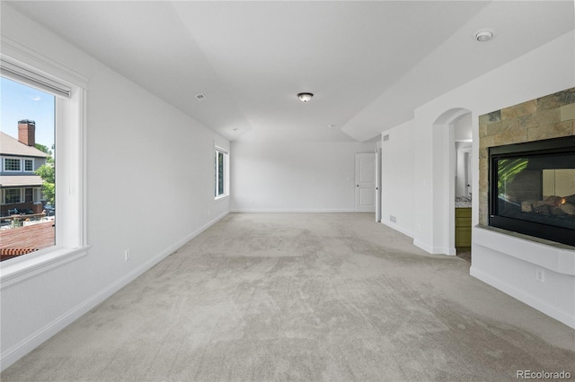 14325 N Santa Fe St, Broomfield, CO 80023 - unfurnished living room featuring light colored carpet, a multi sided fireplace, and arched walkways