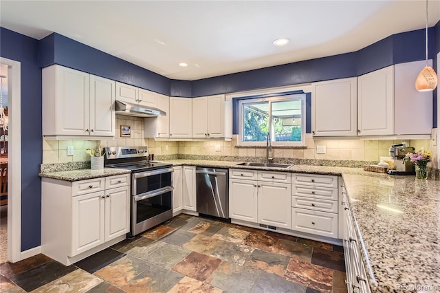 kitchen with appliances with stainless steel finishes, a sink, under cabinet range hood, white cabinetry, and backsplash