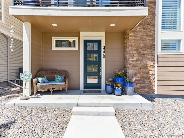 doorway to property with a balcony and covered porch