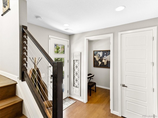 entrance foyer with baseboards, light wood-type flooring, stairway, and recessed lighting