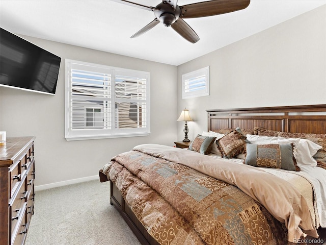 bedroom with light colored carpet, baseboards, and a ceiling fan