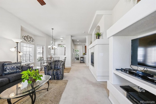 3742 E 127th Ln, Thornton, CO 80241 - living room featuring light colored carpet, ceiling fan, a chandelier, and a glass covered fireplace