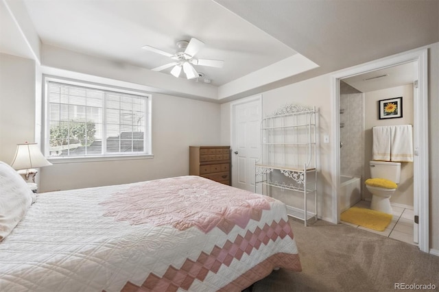 3742 E 127th Ln, Thornton, CO 80241 - carpeted bedroom featuring tile patterned flooring, ensuite bathroom, a ceiling fan, and a tray ceiling