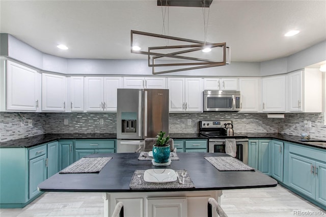 kitchen featuring blue cabinetry, white cabinets, and stainless steel appliances