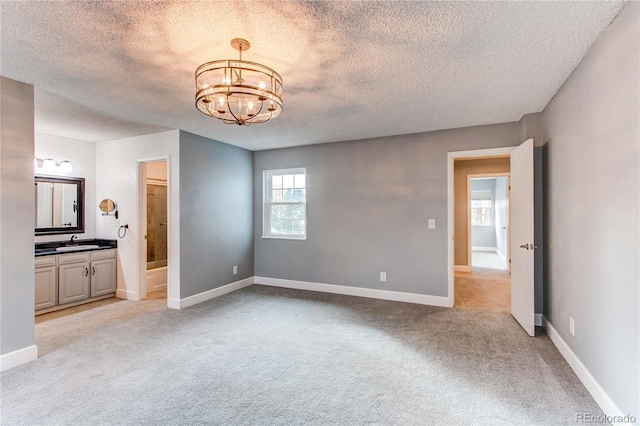 2790 S Wheeling Way, Aurora, CO 80014 - unfurnished bedroom featuring a textured ceiling, a chandelier, light carpet, and ensuite bathroom