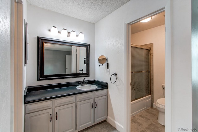 full bathroom with vanity, enclosed tub / shower combo, a textured ceiling, and toilet