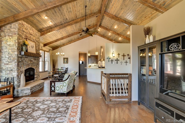 living room with a stone fireplace, beam ceiling, and dark hardwood / wood-style flooring