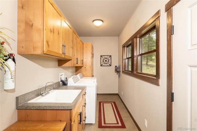 laundry room with sink, washer and clothes dryer, light tile patterned floors, and cabinets