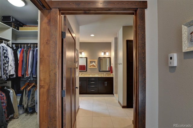 corridor with light tile patterned floors and sink