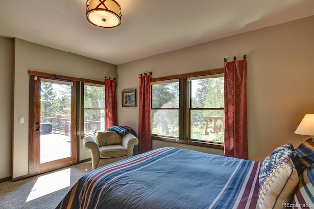 bedroom featuring carpet flooring, multiple windows, and access to outside