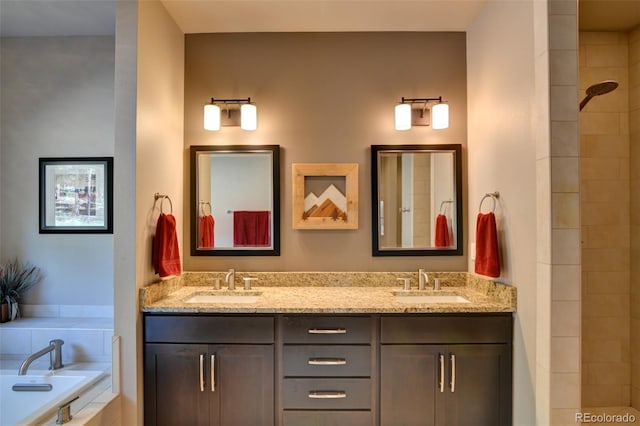 bathroom with tiled bath and dual bowl vanity