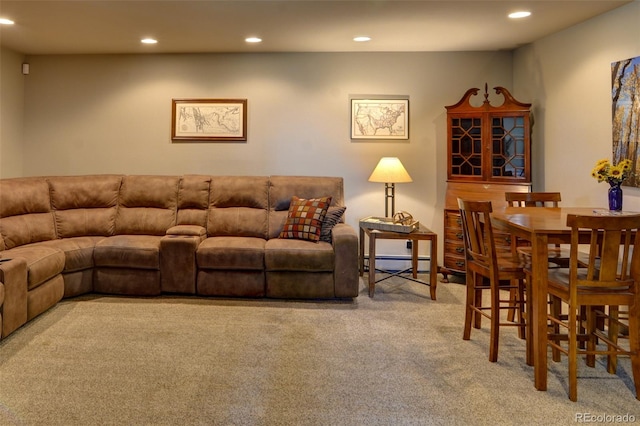 living room with a baseboard heating unit and light carpet