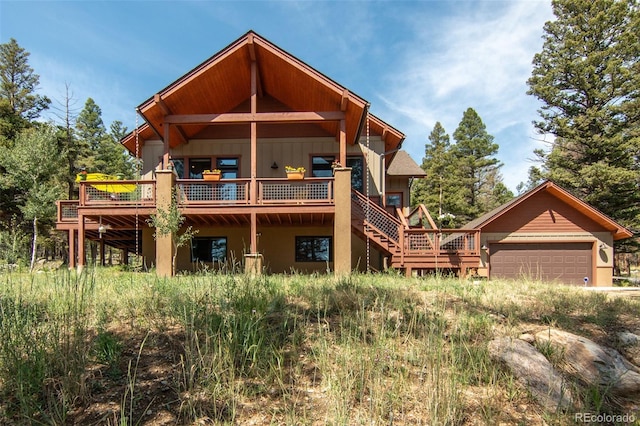 rear view of house with a wooden deck and a garage