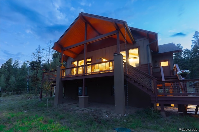 back house at dusk featuring a deck