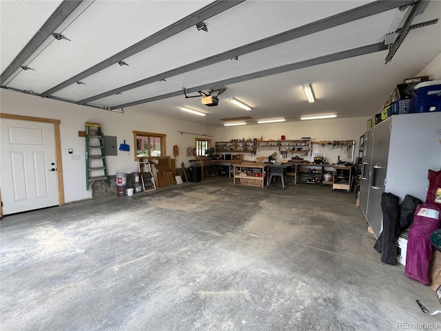 garage featuring a garage door opener, a workshop area, and electric panel