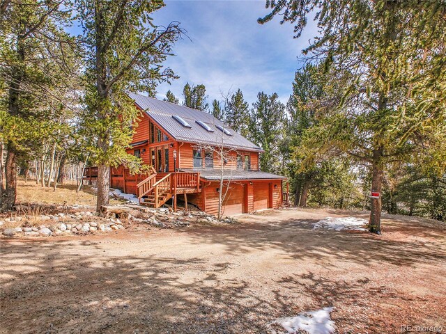 385 Pine Dr, Fairplay, CO 80440 - view of front of home with stairway, metal roof, an attached garage, driveway, and a deck