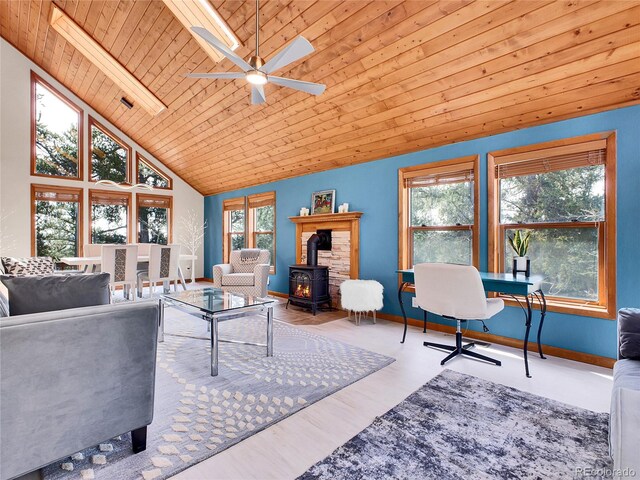 385 Pine Dr, Fairplay, CO 80440 - living area featuring wooden ceiling, a ceiling fan, a wood stove, and plenty of natural light