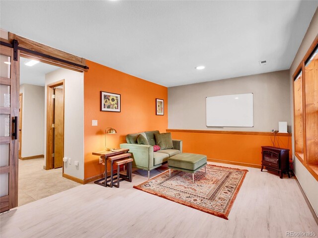 385 Pine Dr, Fairplay, CO 80440 - living area with a barn door, wood finished floors, a wood stove, baseboards, and recessed lighting