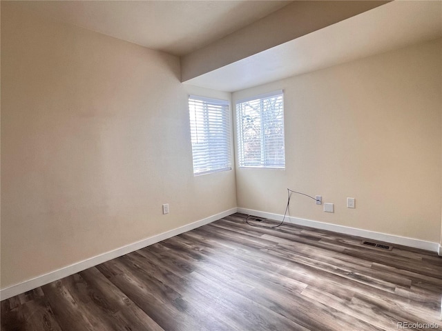 unfurnished room with dark wood-type flooring