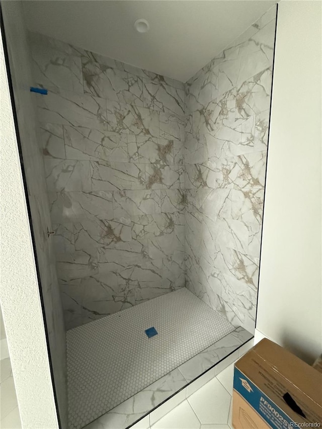 bathroom featuring tile patterned floors and a tile shower