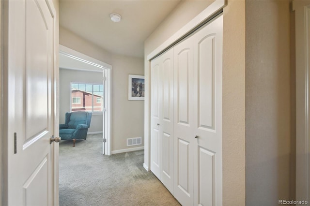 hall with light colored carpet