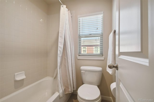 bathroom with shower / bath combo, a healthy amount of sunlight, and toilet