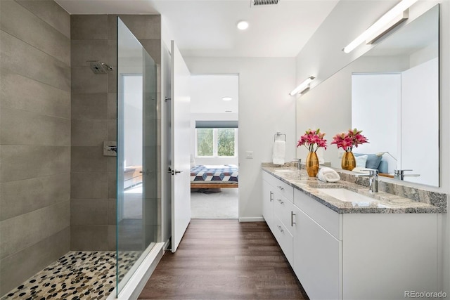 bathroom with vanity, wood-type flooring, and tiled shower