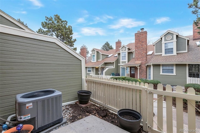 view of patio / terrace with central air condition unit, a residential view, and fence