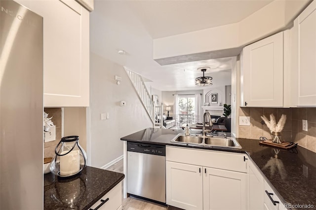 kitchen featuring sink, backsplash, stainless steel dishwasher, and white cabinetry