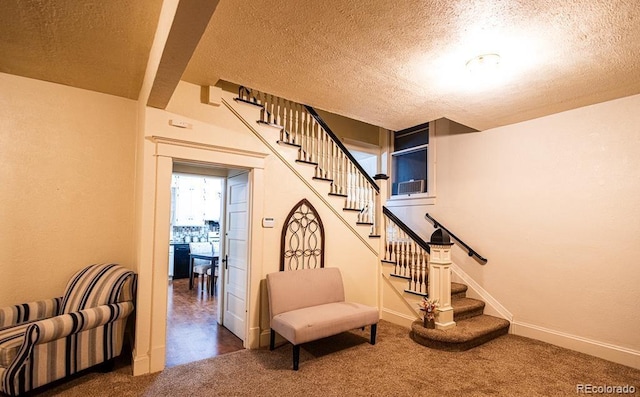 stairs with beam ceiling, carpet floors, and a textured ceiling