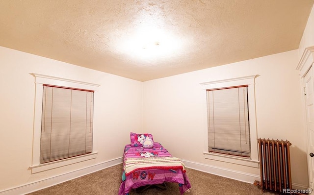 carpeted bedroom featuring radiator heating unit and a textured ceiling